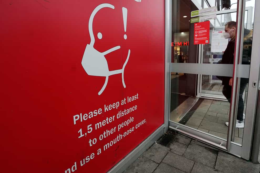 A sign reminds of the need for face masks at a train station in Cologne, Germany (Martin Meissner/AP)