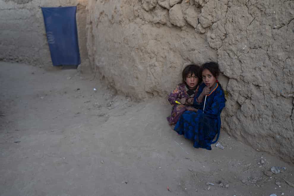 Girls play outside a mud brick house at a camp for internally displaced people in Kabul, Afghanistan (Petros Giannakouris/AP)