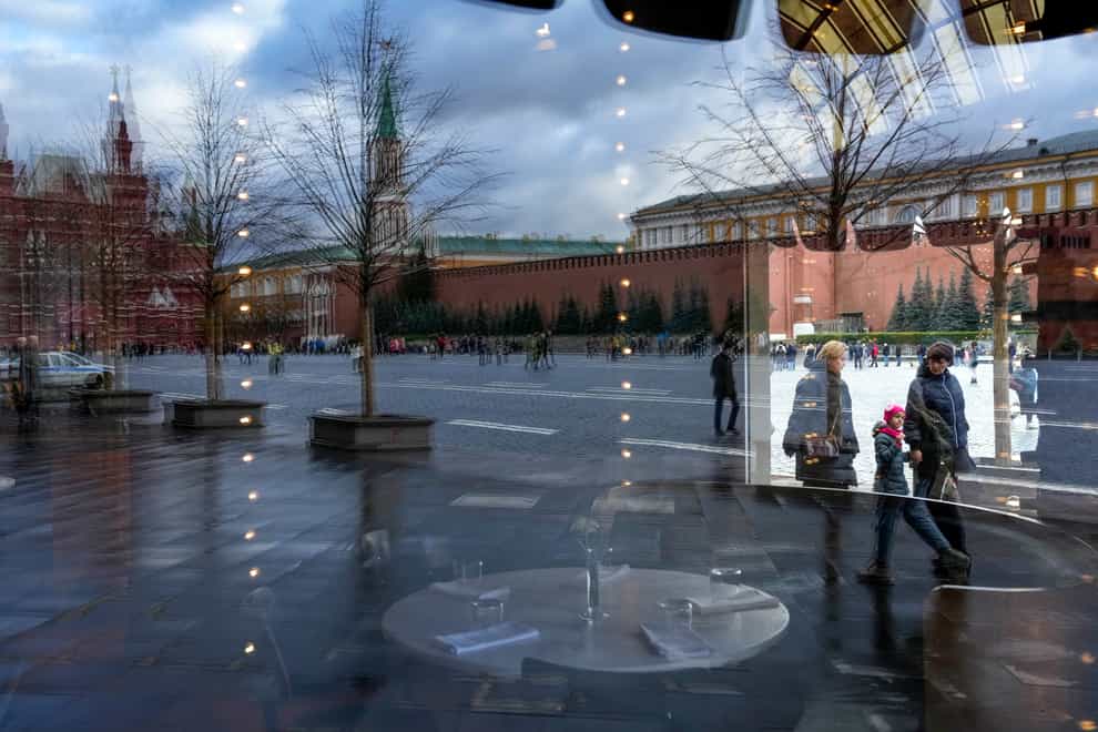 Red Square and the Kremlin Wall are reflected in a window of an empty Bosco cafe in the Gum, the State Shop in Red Square, which is closed due to Covid-19 in Moscow, Russia (Alexander Zemlianichenko/AP)
