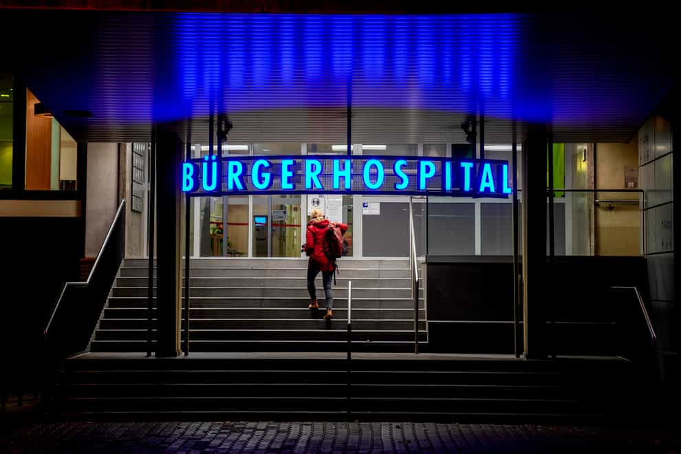 A woman walks up the stairs of a hospital in Frankfurt (Michael Probst/AP)