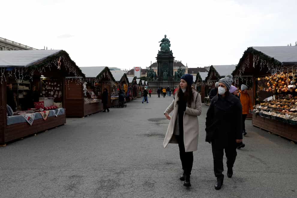 People walk over a nearly deserted Christmas market in Vienna, Austria (Lisa Leutner/AP)