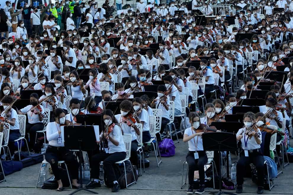 Members of the National Orchestra System play a 12-minute Tchaikovsky piece to try and break a Guinness World Record (Ariana Cubillos/AP)