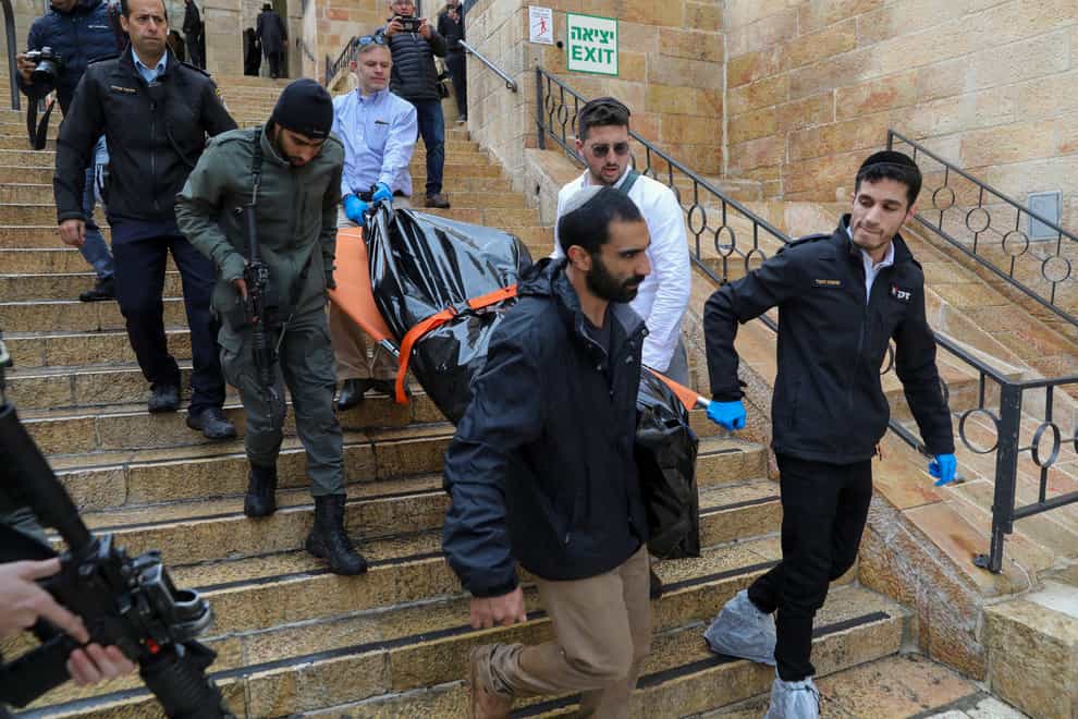 The body of a Palestinian man who was fatally shot by Israeli police is taken away (Mahmoud Illean/AP)