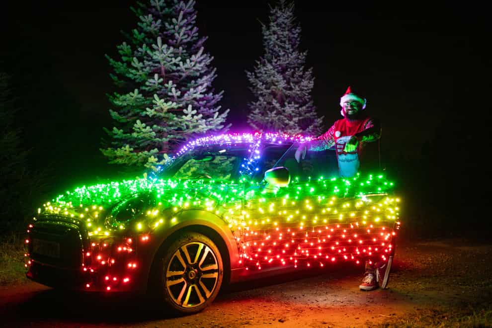 Nico Martin with a Mini Electric wrapped in thousands of Christmas fairy lights (Jacob King/PA)