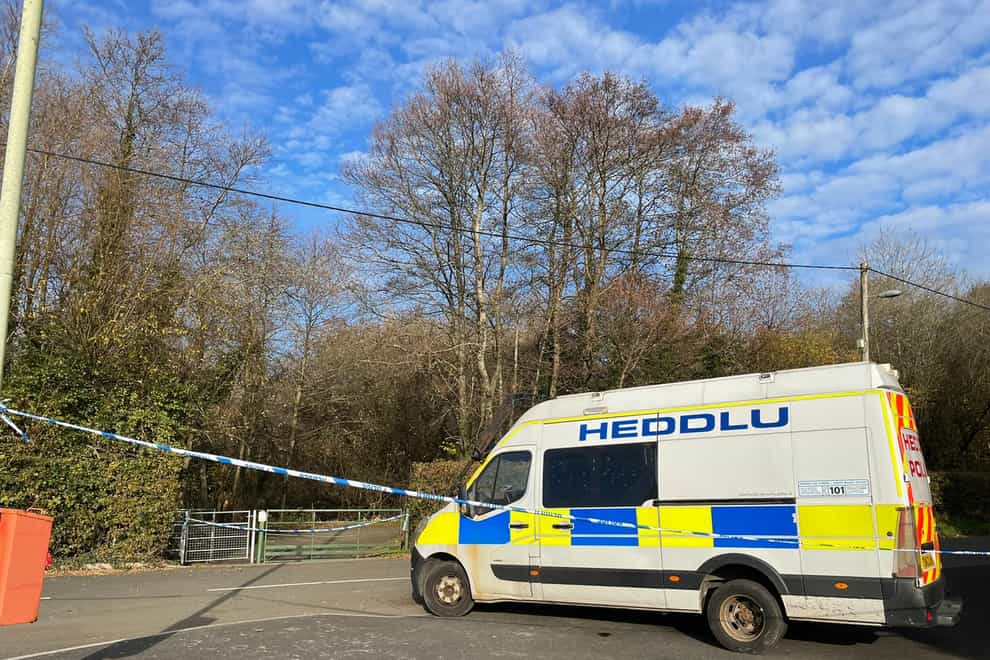 Police block entrance on Heol Dowlias to woodland area behind house where woman’s body was discovered (Bronwen Weatherby/PA)