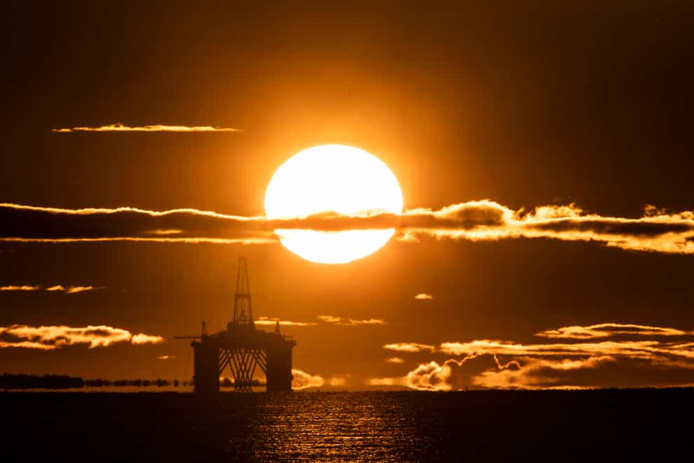 The sun rises behind an oil platform in the North Sea (Jane Barlow/PA)