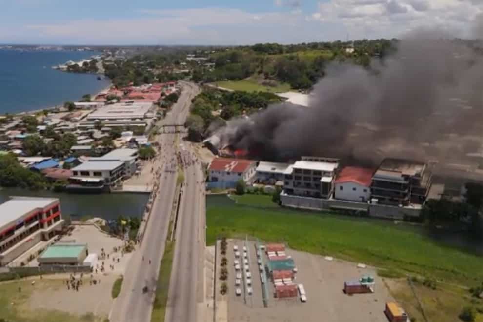 Smoke rises from burning buildings during a protest in Honiara, Solomon Islands (Australian Broadcasting Corporation via AP)