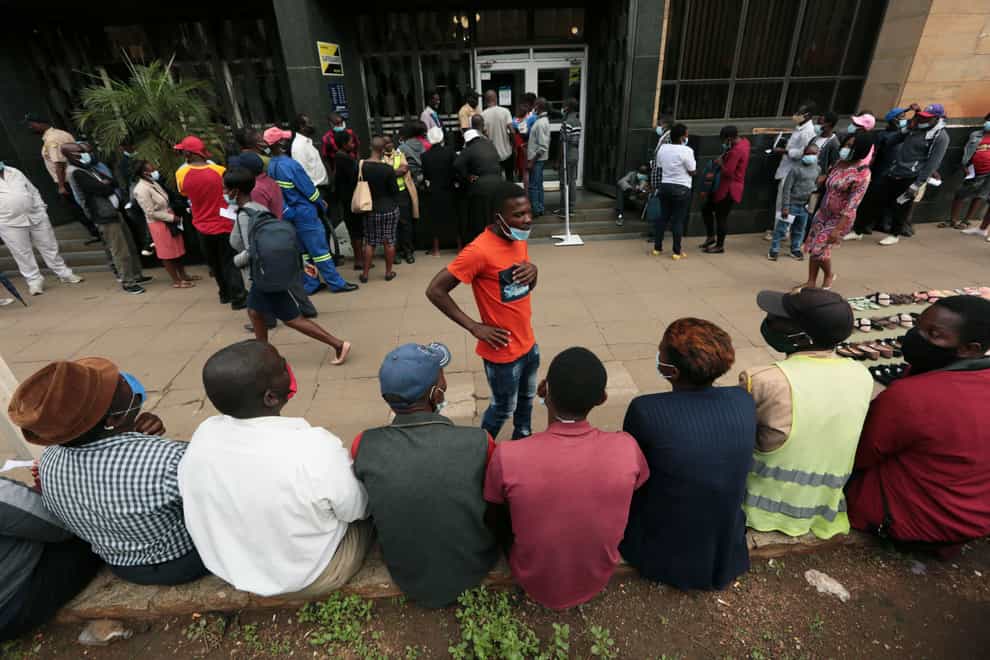 People gather outside a bank while waiting to withdraw cash in Harare, Zimbabwe, after news of a new, potentially more transmissible Covid-19 variant emerging in southern Africa (Tsvangirayi Mukwazhi/AP))