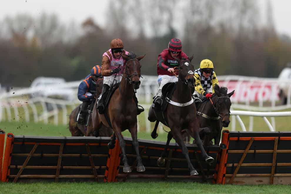 Elle Est Belle (left) about to take command in the Ladbrokes Mares’ Novices’ Hurdle at Newbury (Steven Paston/PA)