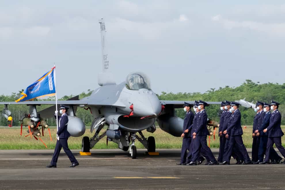 Taiwanese Air Force personnel pass one of the upgraded F-16V fighter jets at a base in Chiayi, south-western Taiwan (Johnson Lai/AP)