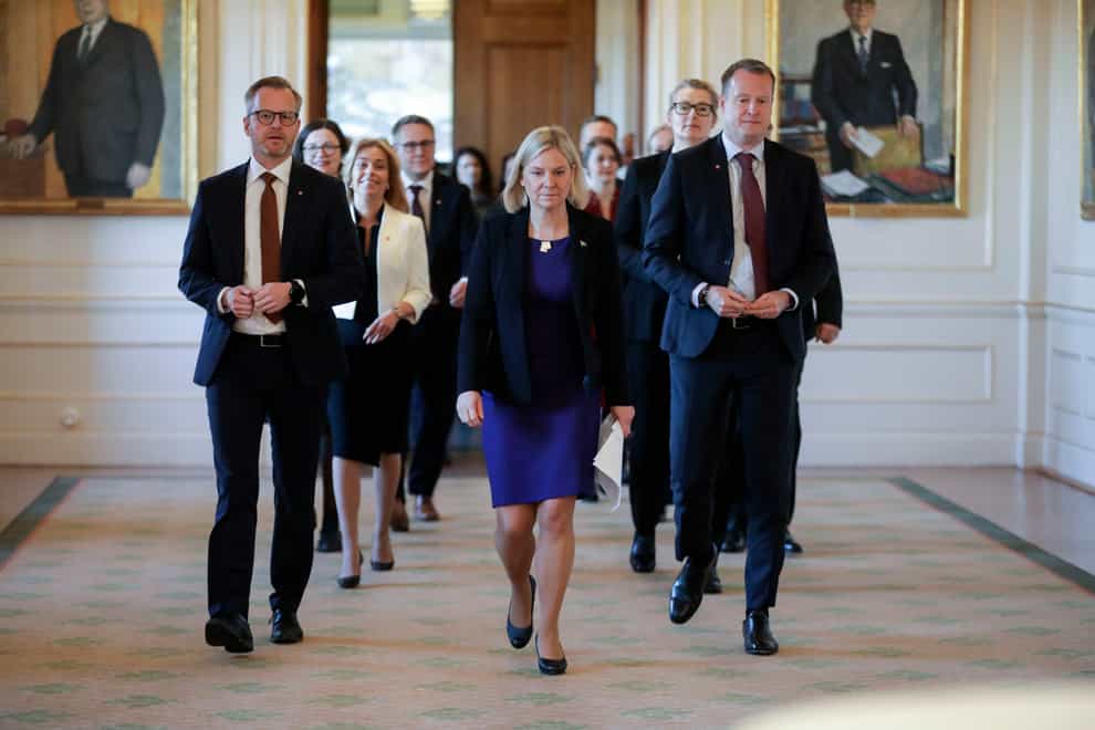 Swedish prime minister Magdalena Andersson, centre, is followed by her new cabinet members as they arrive for a press conference, in Stockholm (TT via AP)