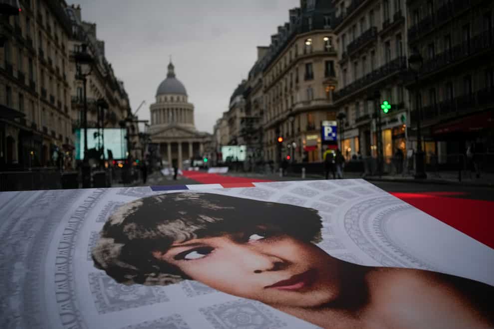 Pictures of Josephine Baker and a red carpet lead to the Pantheon monument, rear, in Paris, France, Tuesday, Nov. 30, 2021 , where Baker is to symbolically be inducted, becoming the first Black woman to receive France’s highest honor. A coffin carrying soils from the U.S., France and Monaco will be deposited inside the Pantheon. Her body will stay in Monaco at the request of her family. (AP Photo/Christophe Ena)