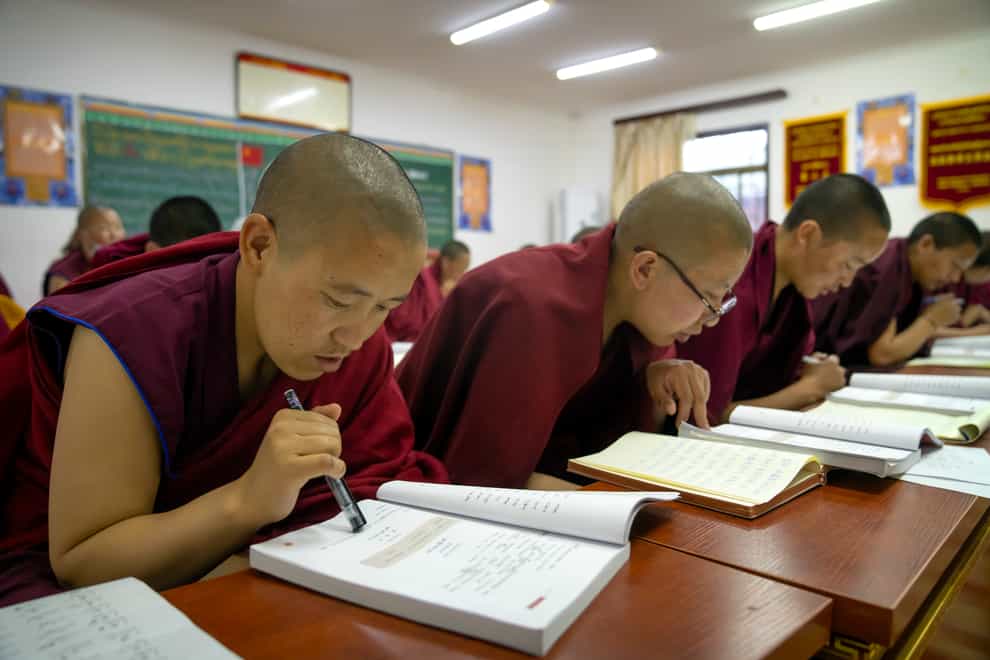 Tibetan Buddhist monks study their text books as part of lessons in Mandarin (AP Photo/Mark Schiefelbein)