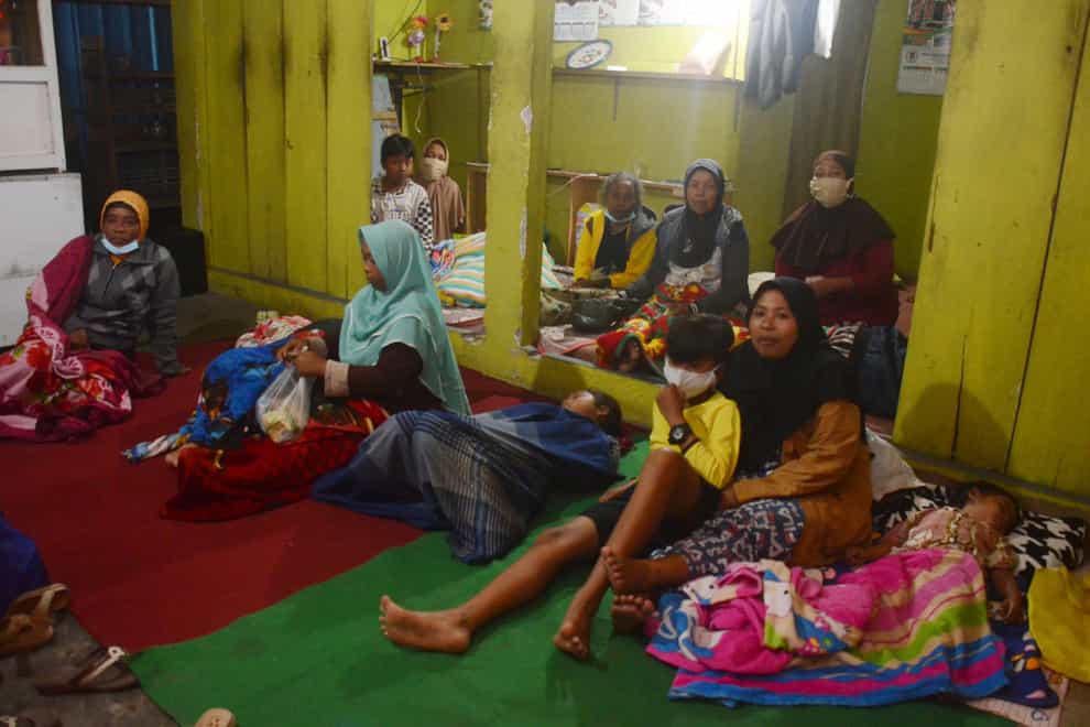 Villagers rest at a temporary shelter (AP)