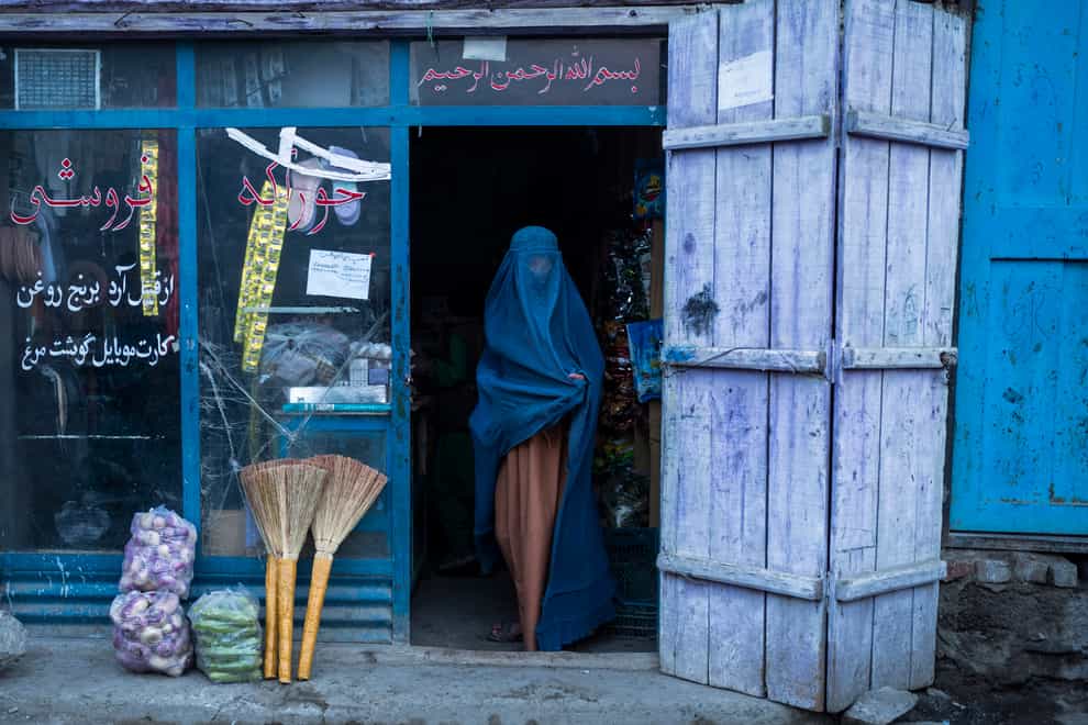 An Afghan woman wearing a burka leaves a shop in Kabul (Petros Giannakouris/AP)