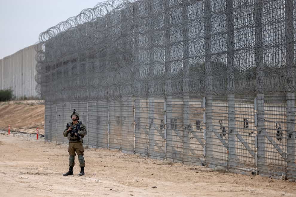 An Israeli soldier stands guard during a ceremony to open the newly completed barrier along the Israel/Gaza border (Tsafrir Abayov/AP)