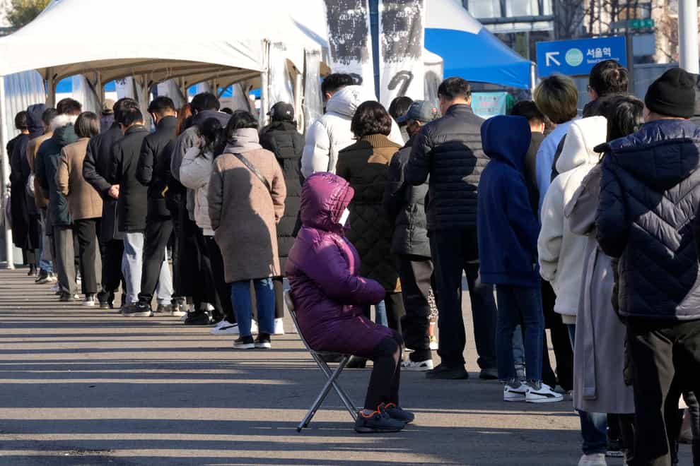 People queue for coronavirus testing at a makeshift testing site in Seoul (AP)