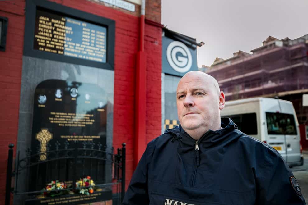 Mark Sykes stands at the memorial to those killed during the Sean Graham Bookmakers attack in 1992 (PA)