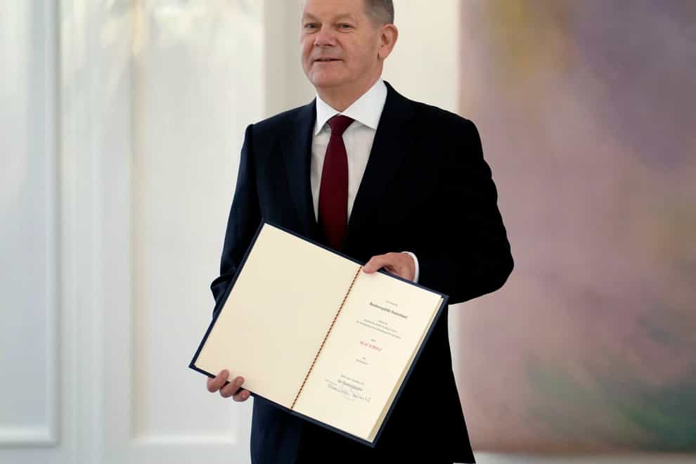 German Chancellor Olaf Scholz holds his letter of appointment presented by President Frank-Walter Steinmeier (Michael Sohn/AP)