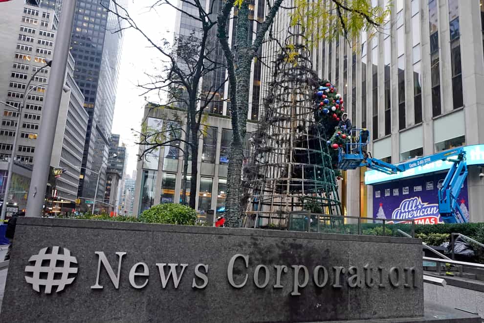 A worker disassembles a Christmas tree outside Fox News headquarters (Richard Drew/AP)
