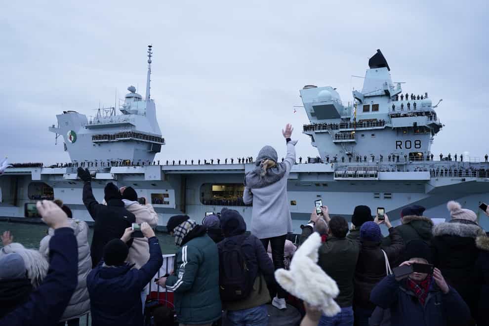 People wave as the Royal Navy’s aircraft carrier HMS Queen Elizabeth returns to Portsmouth Naval Base (Andrew Matthews/PA)