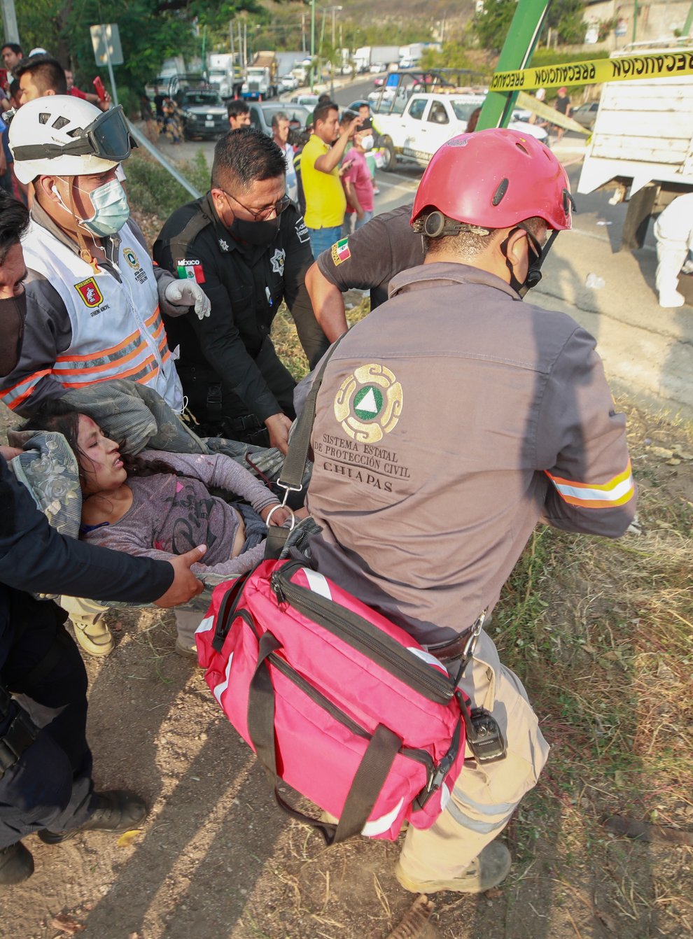 An injured woman is helped by rescue personnel (STR via AP)