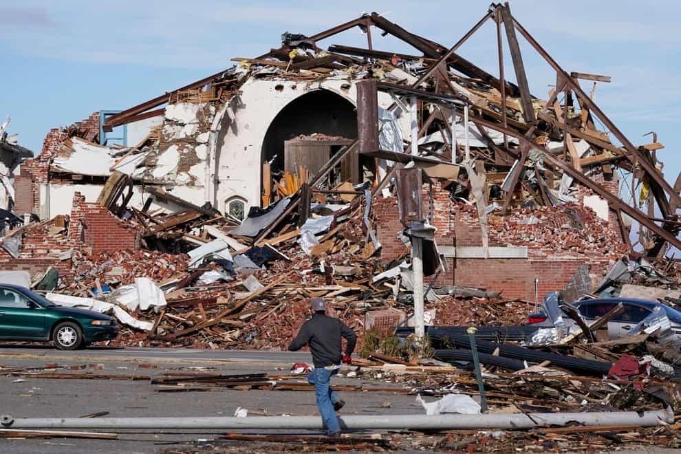People survey damage from a tornado in Mayfield, Kentucky (AP Photo/Mark Humphrey)