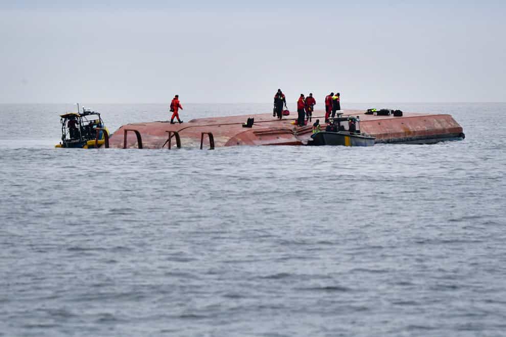 Divers work on the capsized Danish cargo ship Karin Hoej following the collision (Johan Nilsson/TT via AP)