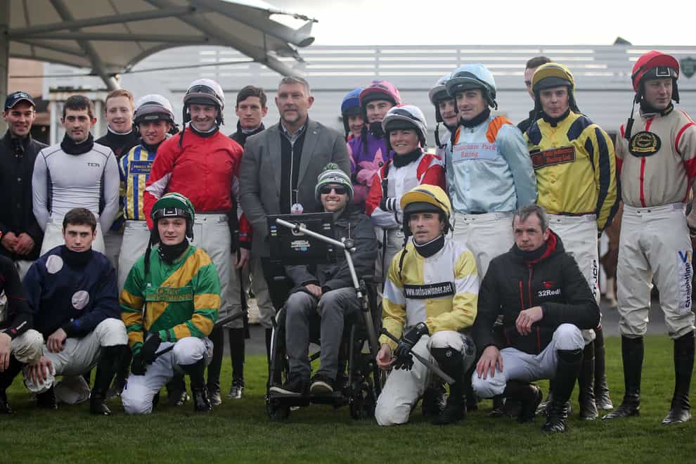 Jockeys pose for a picture with Rob Burrow at Catterick racecourse (Simon Marper/PA)