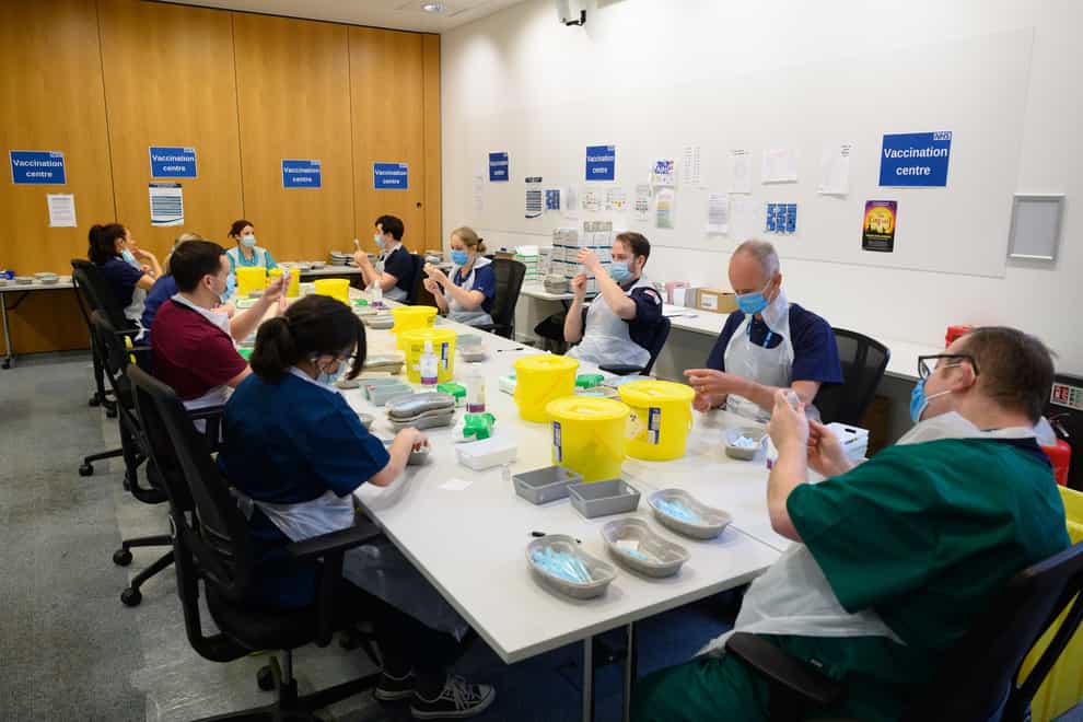 Medical staff and volunteers prepare shots of the Moderna Covid-19 vaccine at a vaccination centre in Ramsgate, Kent (Leon Neal/PA)