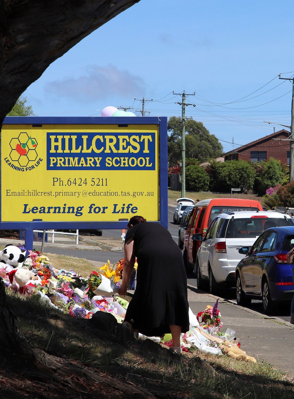 People leave flowers and tributes outside Hillcrest Primary School in Devonport, Tasmania (Ethan James/AAP Image via AP)