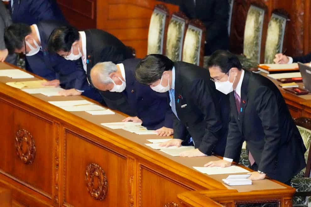 Japanese Prime Minister Fumio Kishida, right, bows with his cabinet ministers as the supplementary budget for the fiscal year was approved (Kyodo News via AP)