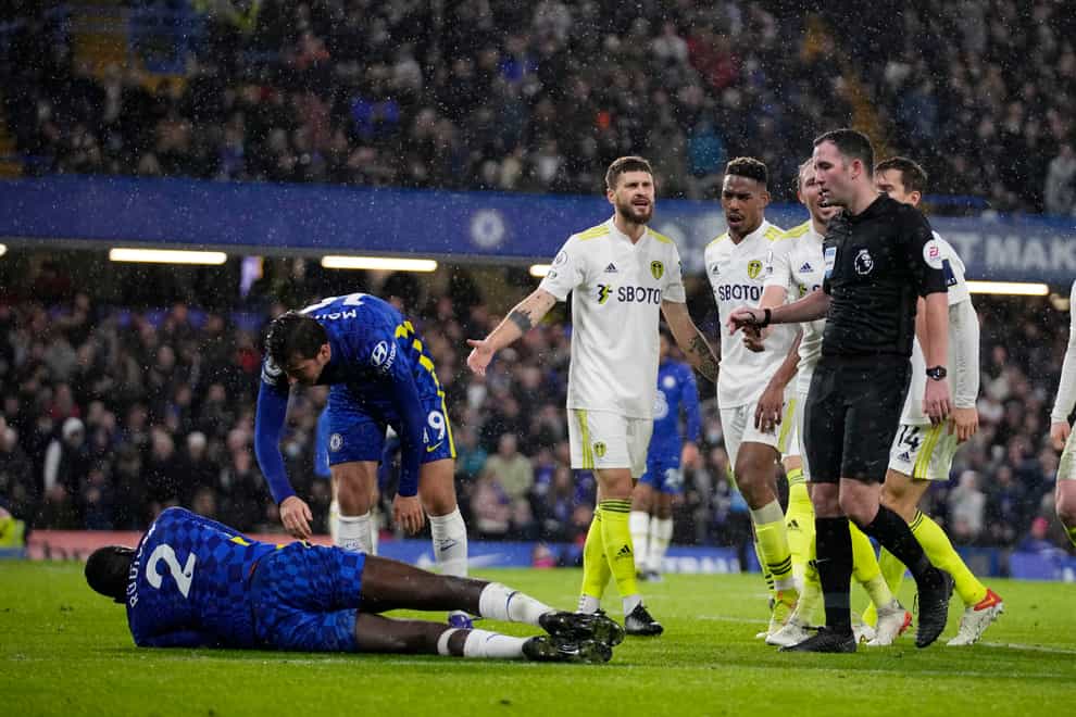 Leeds players surrounded referee Chris Kavanagh after he awarded a late penalty against them at Chelsea (Matt Dunham/AP)