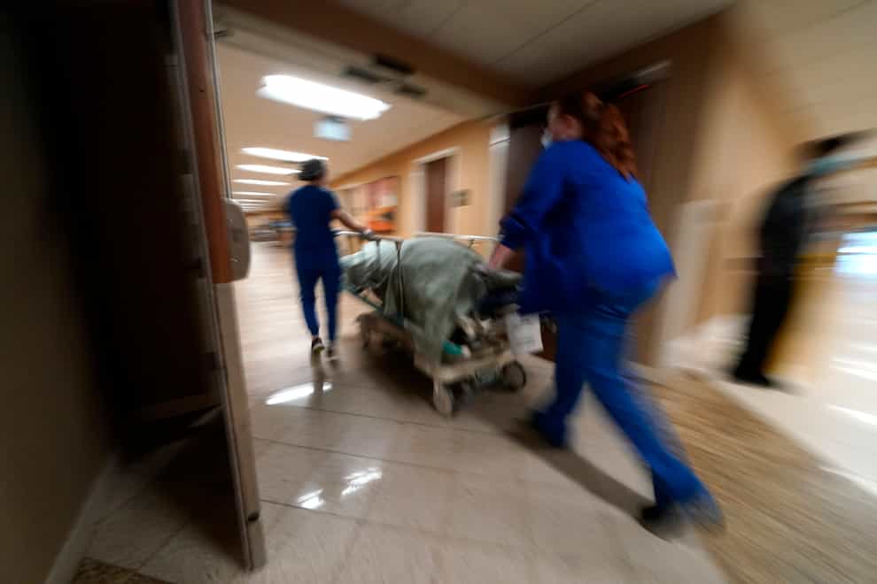 Medical staff move a Covid-19 patient who died to a loading dock to hand off to a funeral home van, at the Willis-Knighton Medical Center in Shreveport (AP)