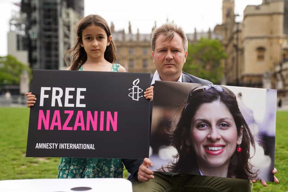 Richard Ratcliffe and his daughter Gabriella hold signs in Parliament Square, London, to mark the 2,000th day Nazanin Zaghari-Ratcliffe has been detained in Iran, back in September (Kirsty O’Connor/PA)