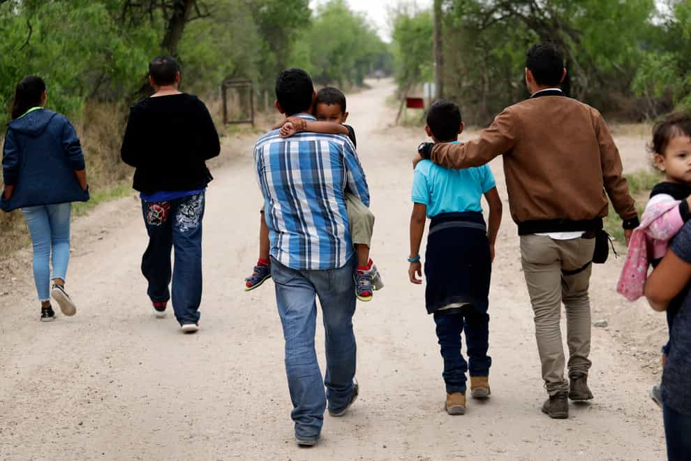 Migrant families walk from the Rio Grande, the river separating the US and Mexico in Texas. A Biden administration effort to reunite children and parents has made increasing progress (Eric Gay/AP)