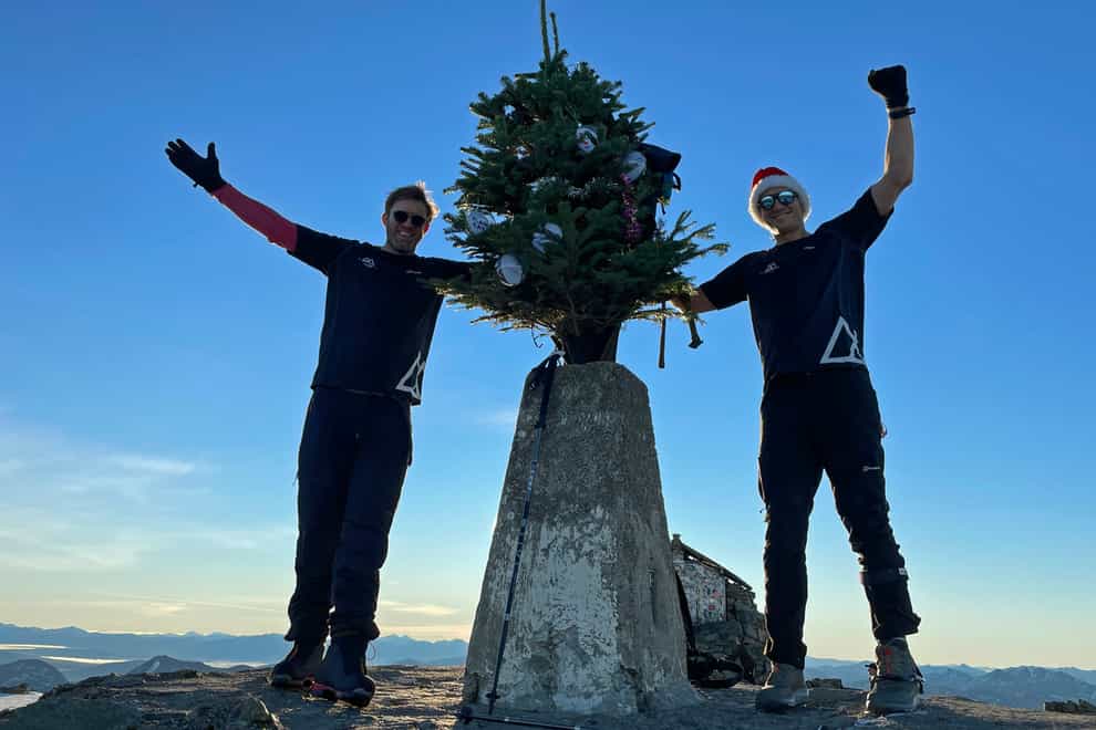 Ed Jackson (right) and Ross Stirling have successfully carried the tree to the summit of Ben Nevis during their 12 Peaks of Christmas challenge (Ed Jackson/PA)