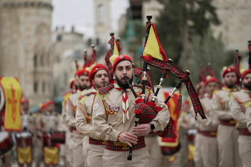 Palestinian scout band members parade through Manger Square at the Church of the Nativity (Majdi Mohammed/AP)