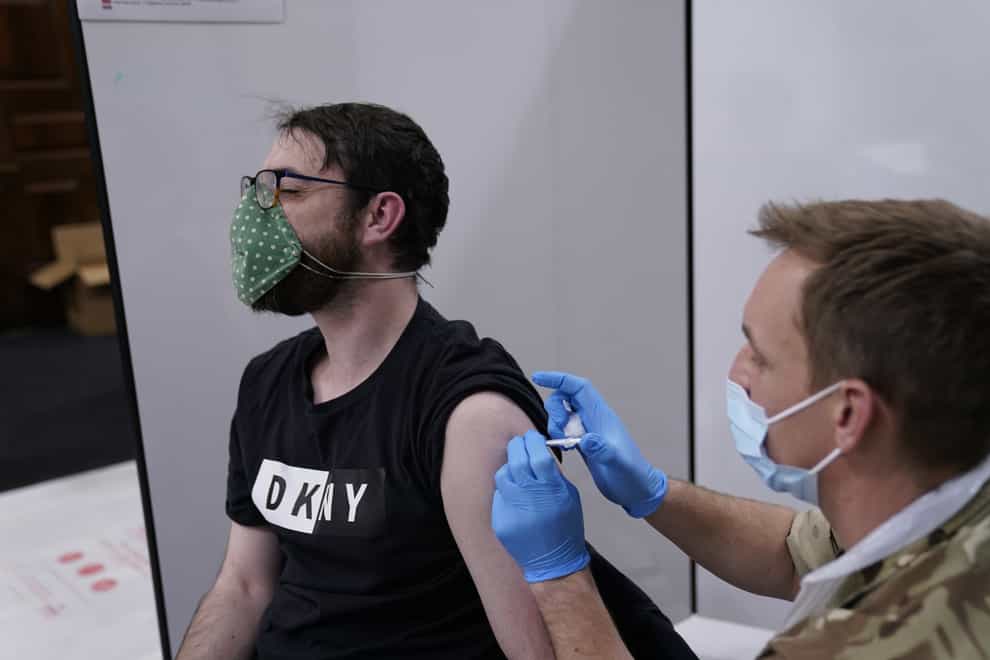 Bomdardier Ian Bloomfield of the 5th Regiment Royal Artillery administers a vaccine at the Covid-19 vaccination centre in Rates Hall, Manchester (Danny Lawson/PA)