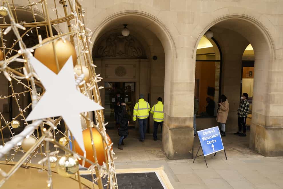 People arrive at Rates Hall Covid-19 vaccination centre, near St Peter’s Square in Manchester (Danny Lawson/PA)