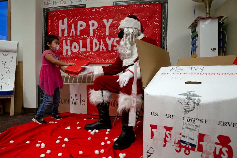 Santa hands a gift to a student in Alaska (Cpl Brendan Mullin/US Marine Corps via AP )