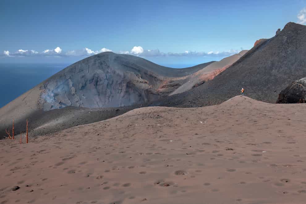 Scientists walk near the crater at the Cumbre Vieja volcano (Saul Santos/AP)