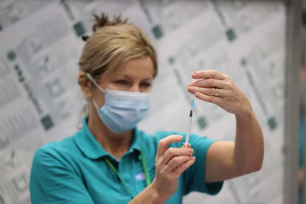 A vaccinator prepares vaccines at a Covid-19 booster vaccination centre at the Titanic Exhibition Centre in Belfast (Liam McBurney/PA)