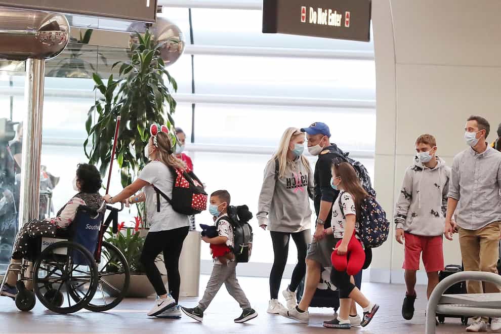 Travellers at Orlando International Airport (Stephen M Dowell/Orlando Sentinel via AP)