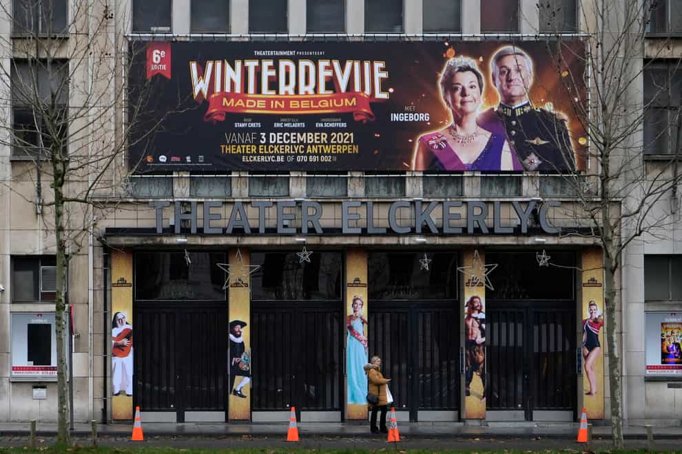 A woman stands in front of a closed theatre in Antwerp, Belgium (Virginia Mayo/AP)