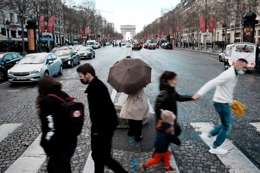 People cross the Champs Elysees avenue in Paris (Thibault Camus/AP)