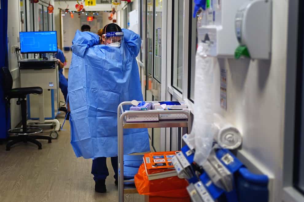 A nurse puts on PPE in a ward for Covid patients at King’s College Hospital, in south-east London (Victoria Jones/PA)