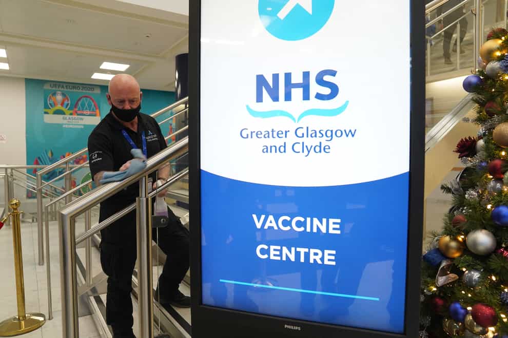 A worker cleans a banister at a Covid-19 vaccination centre at Hampden Park in Glasgow (Andrew Milligan/PA)
