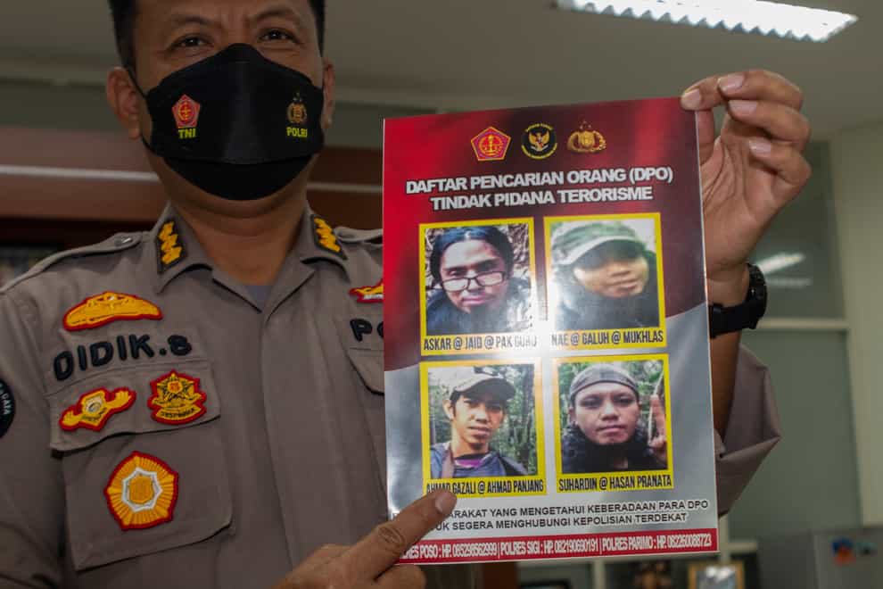Central Sulawesi Regional Police spokesperson Colonel Didik Supranoto displays a photo of Ahmad Gazali, bottom left (Mohammad Taufan/AP)