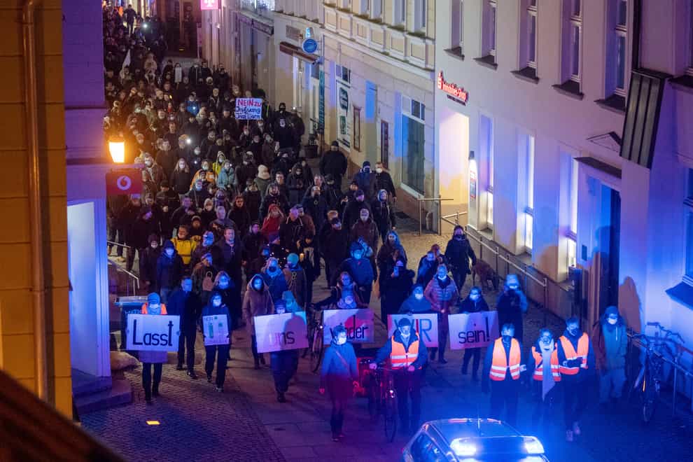 Demonstrators walk through Greifswald, Germany, in protests against coronavirus restrictions (Stefan Sauer/dpa via AP)